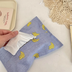Close-up of a purple cotton tissue pouch with yellow banana prints and central opening