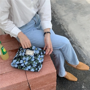 Close-up of floral jacquard canvas bag with a Pleasant Time label held by a model
