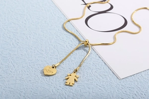 Detail of adjustable gold snake chain with heart and girl pendants engraved with Love