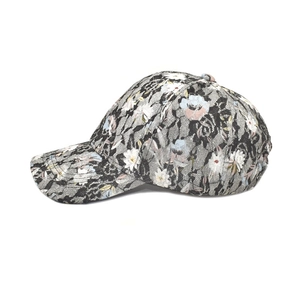 Détail de la dentelle noire sur le tissu à motif floral de la casquette de baseball