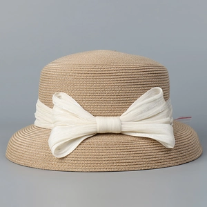 Dettaglio della trama in paglia e fiocco in chiffon bianco su cappello estivo
