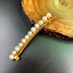 Elegant gold metal hair clip adorned with a row of natural white freshwater pearls