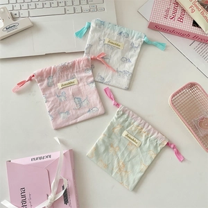 Detail of three cotton drawstring pouches with cute cat prints for small jewelry storage