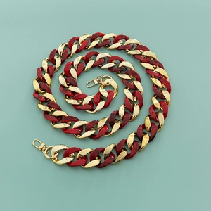 Detail of red tortoiseshell resin links joined with gold metal loops and spring clasps