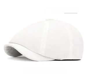 Detail of white cotton octagonal newsboy hat showing brim stitching and fabric texture
