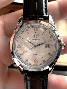 Close-up of champagne dial quartz watch with black leather strap and calendar display