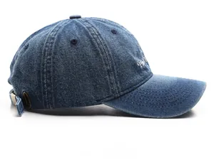 Detail view of washed navy denim baseball cap featuring white side embroidery and metal buckle