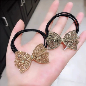 Handheld view of elastic hair ties with sparkling rhinestone butterfly bow decorations