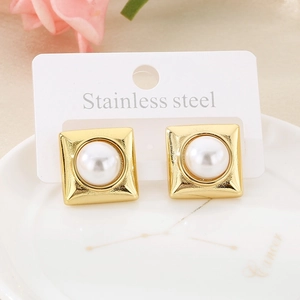 Close-up of geometric gold stainless steel stud earrings with white pearls on a display card