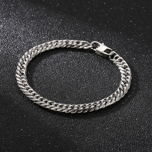 Détail du bracelet gourmette en argent avec fermoir mousqueton sur fond sombre
