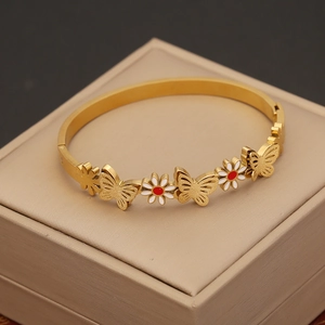 Close-up of gold stainless steel bracelet featuring red-hearted flowers and butterflies