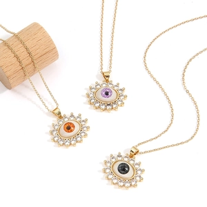 Three gold evil eye necklaces with colorful zircon stones on white background