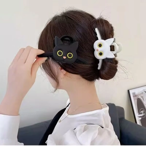 Cat shaped triangle hair claw clips in black and white colors shown on model