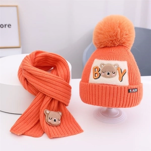 Detail von leuchtend orangefarbenem Strickset für Kinder mit süßer Bärenstickerei