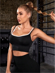 Detail of black yoga vest with white contrast trim and high-waist fitness leggings