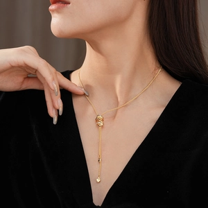 Close-up of golden Y-shaped necklace with heart pendants and adjustable slider on a model