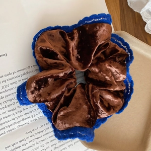 Detail of vintage brown velvet scrunchie with blue crochet lace on a stylist tray