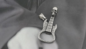 Detail of skull guitar pendant featuring a functional bottle opener in vintage silver steel