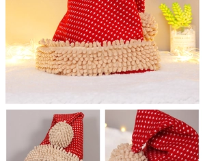 Close-up of red knit Christmas hat with soft beige chenille pompom and fabric texture