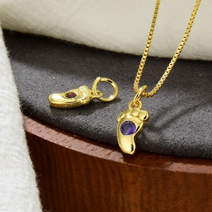 Nahaufnahme goldener Fußabdruck-Anhänger mit violetten Zirkonia für DIY-Schmuck