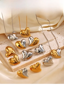Vista macro del set di gioielli a cuore in acciaio inossidabile placcato oro 18K e argento