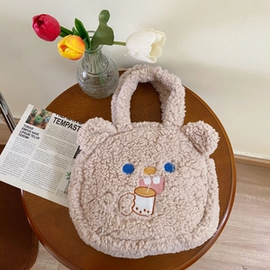 Close-up of fluffy lamb wool teddy bear tote bag with cute embroidery on a wooden table