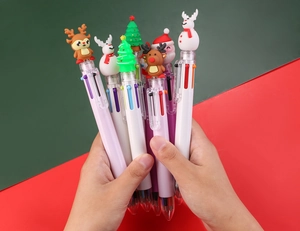 Close-up of Christmas multi-color ballpoint pens with Santa and Reindeer silicone toppers