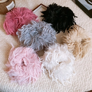 Macro à plat d'élégants élastiques à cheveux en plumes de diverses couleurs sur fourrure