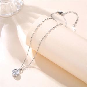 Close-up of a silver Eiffel Tower necklace with a round rhinestone pavé circle pendant