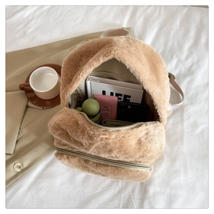 Dettaglio dello zaino in peluche beige che mostra la grande capacità per uso quotidiano