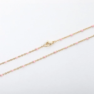 Detail of gold bead chain necklace with pink enamel dots and secure lobster clasp closure