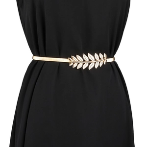 Detailed view of a golden leaf buckle on a metallic stretch belt for dresses