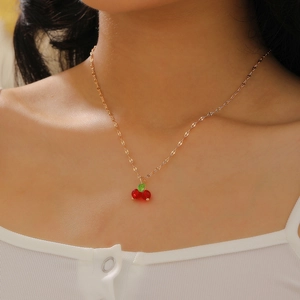 Close-up of sparkling red cherry pendant necklace with cubic zirconia on gold chain