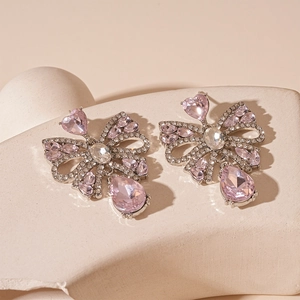 Elegant bow earrings with pink teardrop crystal tassels and sparkling diamond accents