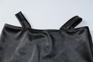 Detail of black PU leather fabric showing glossy texture and high-quality stitching on set