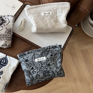 Detailed shot of linen cosmetic bags with waffle texture and paisley floral patterns
