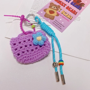 Détail du bijou de sac tissé violet avec cordon bleu, perles et mousqueton en cœur