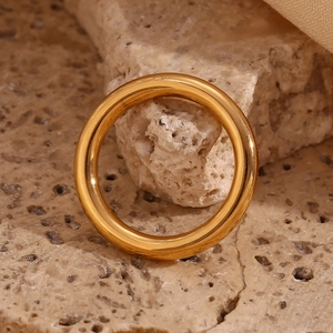 Detail of 18K gold plated stainless steel ring set on a textured natural stone base
