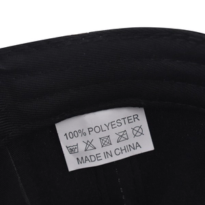 Detail view of the 100% polyester fabric material label inside the black baseball cap