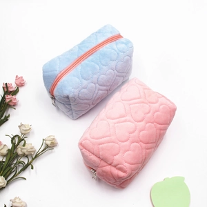 Detail of plush heart-quilted stationery pouches in sky blue and soft pink colors