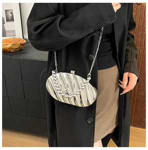 Chic silver shell-shaped acrylic evening clutch with beaded handle shown on model