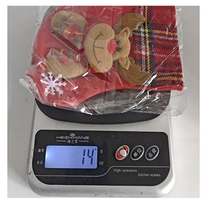 Vue rapprochée du poids de 14g d'un petit sac cadeau chaussette de renne de Noël