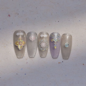 Detail view of silver cat eye press-on nails with holographic palace patterns