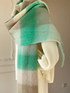 Close-up of mint and grey plaid scarf with soft mohair texture and fringed edges
