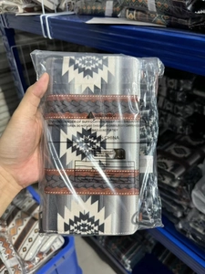 Detail of bohemian woven bag strap with black and white geometric patterns in packaging