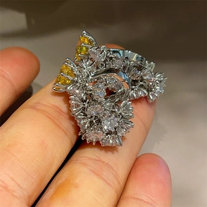 Detail of luxury flower ring with yellow stones and white zircons on silver band