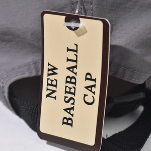 Detail of grey ripstop baseball cap with woven strap and authentic paper hang tag