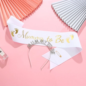 White satin Mummy to Be sash with gold foil and rhinestone tiara on pink background