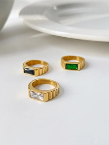 Macro detail of gold stainless steel rings with vertical stripes and rectangular gemstones