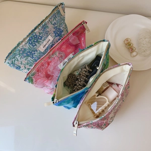 Detail of colorful floral cotton cosmetic bags with metal zippers and fabric labels